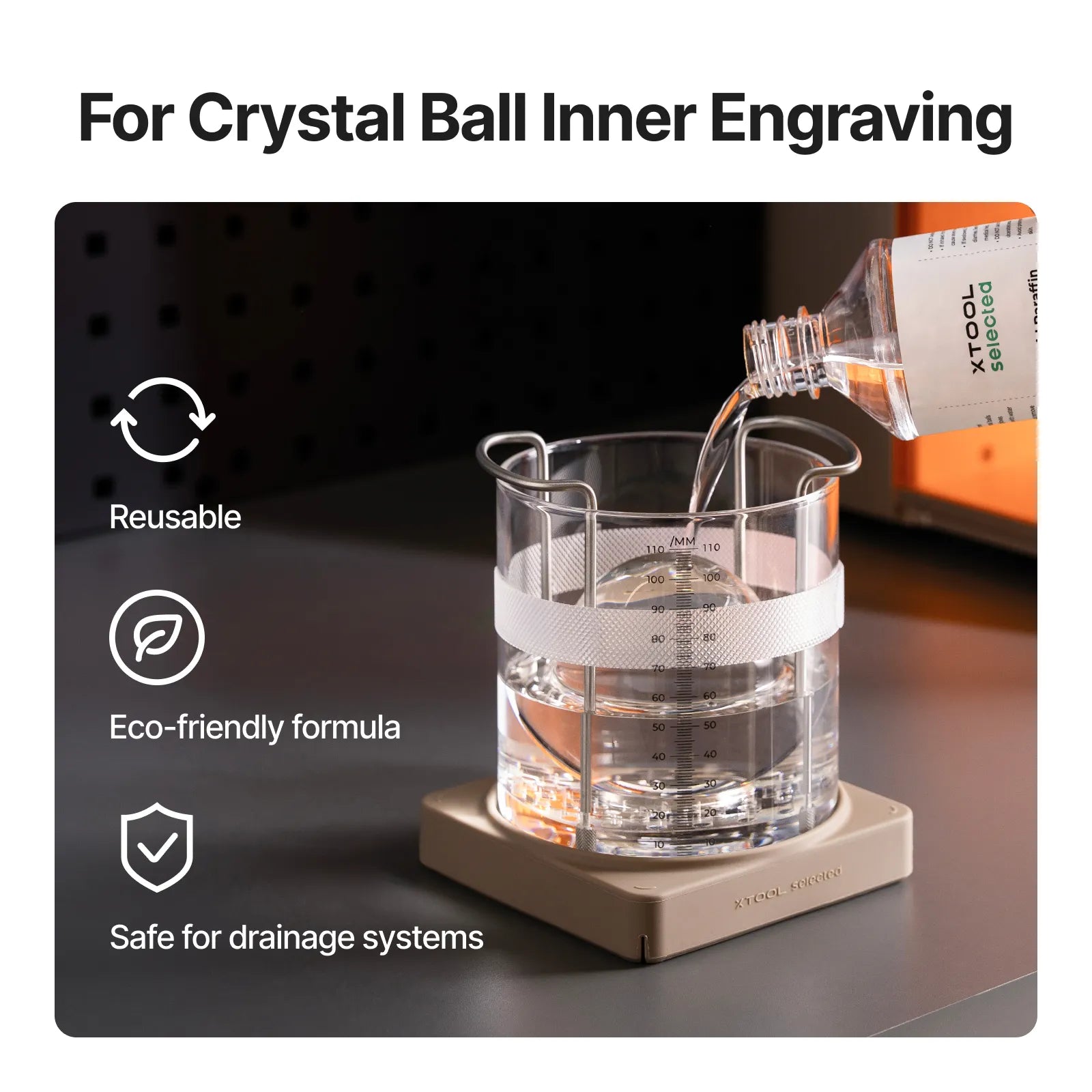 El aceite de grabado interior vertiendose en el vaso graduado con la bola de cristal sujeta por el utillaje
