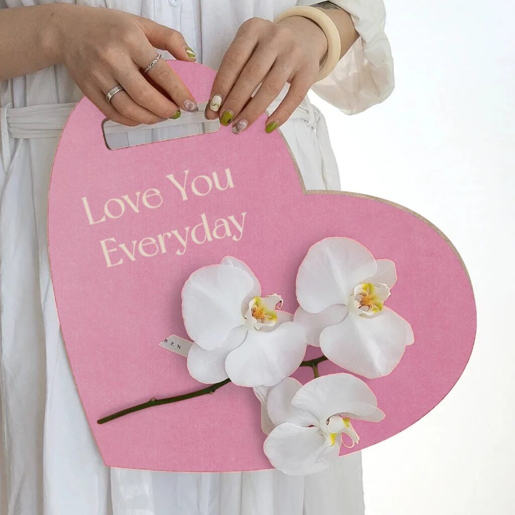 Corazón de DM rosa cortado con láser y grabado con el texto Love You Everyday, con flores de orquídea